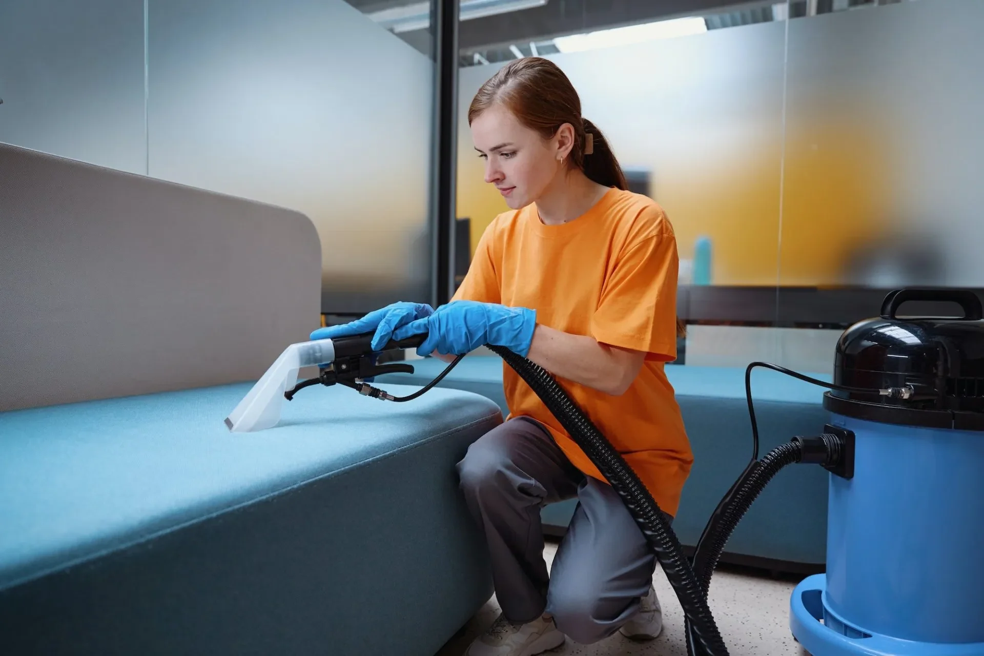 focused-cleaning-service-worker-vacuum-cleaning-the-sofa-e1680687845640